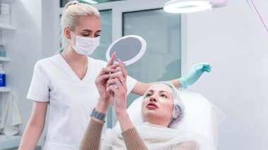 Genç güzellik uzmanı kadın dudaklarına iğne yapmaya hazırlanıyor. Doktor kozmetik uzmanı dudak büyütme prosedürü uyguluyor. Güzellik salonu ve estetik cerrahi kliniği kavramı.