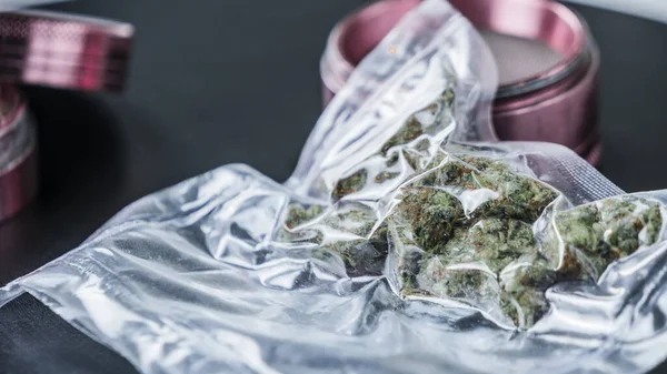 Vakumlu fok torbaları ve öğütücüde tıbbi marihuana tomurcukları yakın plan. Esrar bir bitkisel veya alternatif tıp kavramıdır.