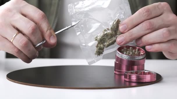 医療用マリファナの芽を持つ真空シールバッグを開く男性の手のクローズアップ 大麻は ハーブや代替医療の概念です — ストック動画