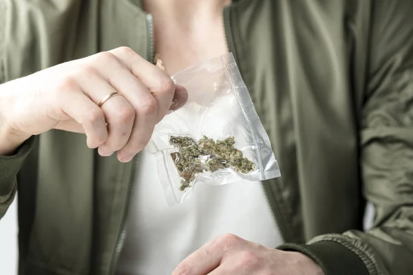 把医用大麻芽放在真空密封袋中的男性手的特写 大麻是一种草药或替代药物的概念 — 图库照片