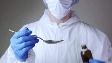 Hasta tedavisi için ilaç kullanan koruyucu kıyafetli genç erkek doktorların yakın çekimleri. Sağlık, hastane veya klinik ve koronavirüs salgını kavramı 