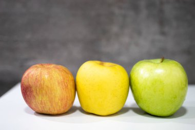 Arka arkaya 3 kırmızı-sarı-yeşil elma.