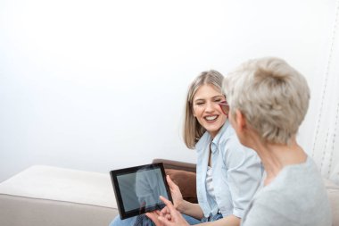 Yaşlı sarışın bir kadın tablet bilgisayar kullanmayı öğreniyor. O istiyor.