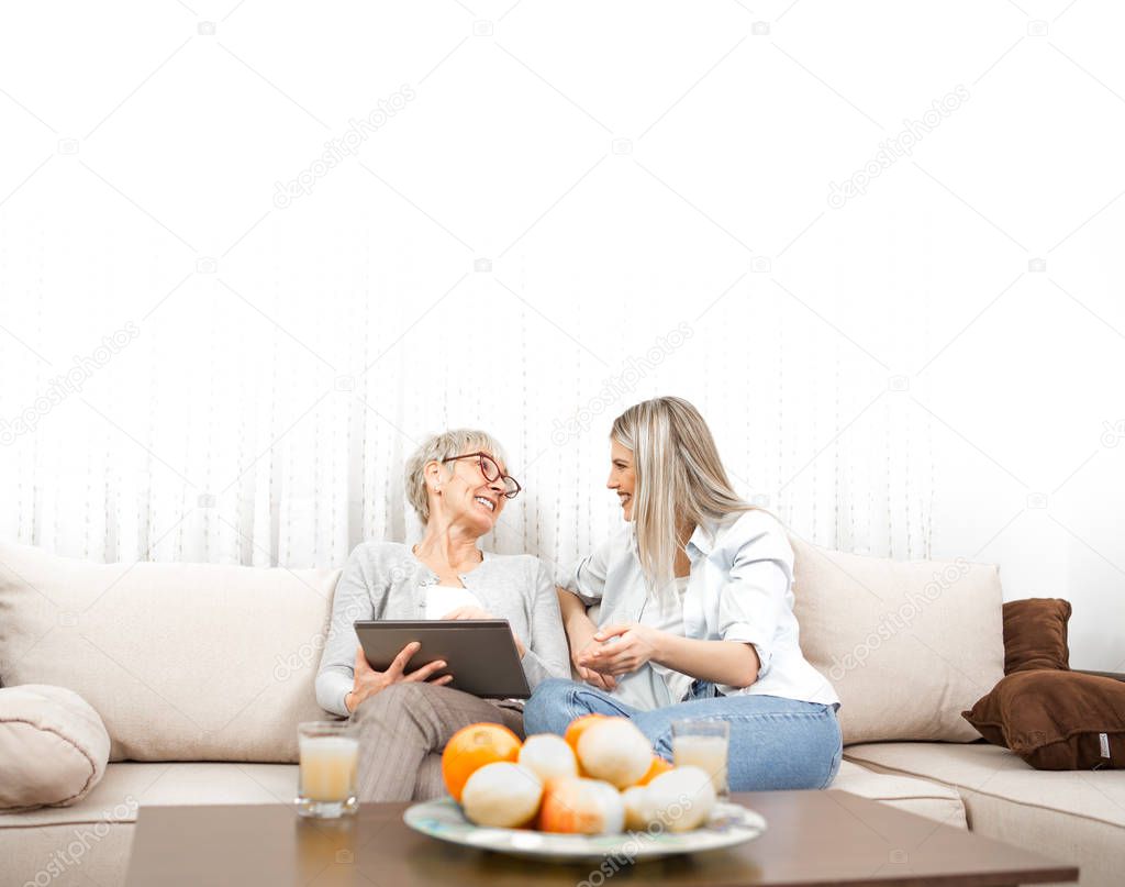 Senior blonde woman learns to use a tablet computer. She wants t
