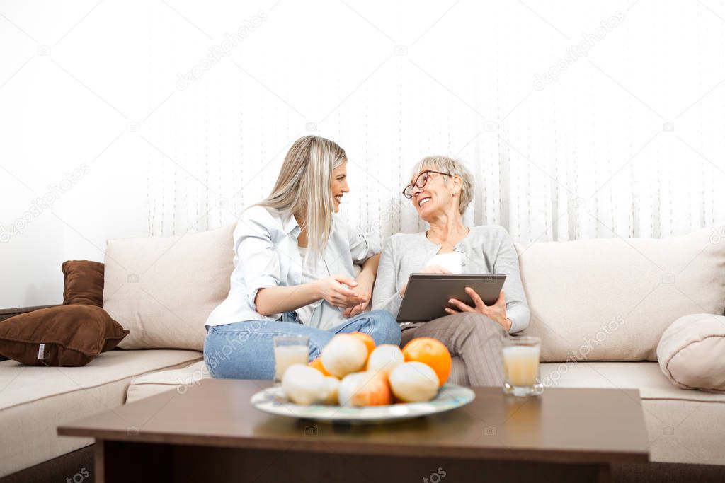 Senior blonde woman learns to use a tablet computer. She wants t