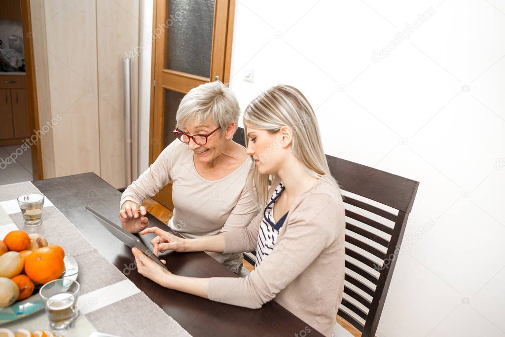 A senior blonde woman learns to use a tablet computer. She wants