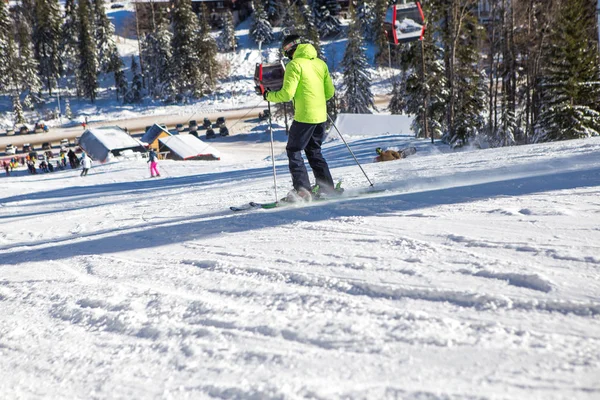 Un hermoso día soleado en la montaña, un esquiador en un jac amarillo — Foto de Stock