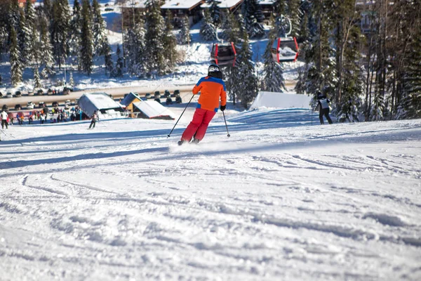 Una bella giornata di sole in montagna, uno sciatore in arancio su — Foto Stock