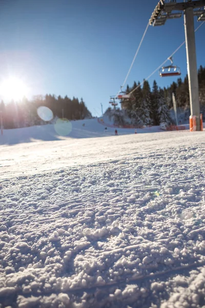 Селективный акцент на снег на лыжном склоне, солнце освещает й — стоковое фото