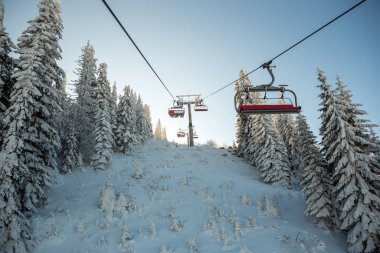 Teleferikten karla kaplı güzel ormana bakın. Dağ, kışın güzel bir günüdür..