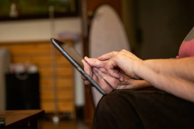 Üst düzey bir kadının eli bilgisayarındaki dokunmatik ekrana dokunuyor. İnternette ilginç içerikler arıyor..