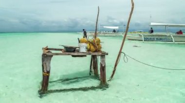 Filipin Denizi teknelerin arka plan üzerinde suda ayakta hindistancevizi ile tablo. 4 k Timelapse - Ağustos 2016, Bohol, Panglao, Filipinler