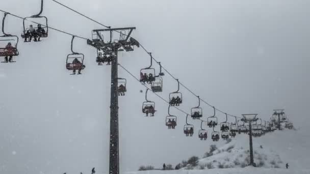 Skiers ride on a ski lift in cloudy weather in the snowfall. 4K TimeLapse. January 2017, Kazakhstan — Stock Video