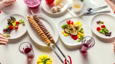 Hizmet ve et, kebap ve salats arkadaşları ile yemek. Üstten Görünüm plakalı yemek masada. Hızlandırılmış ve stop motion, 4k