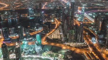 Dubai şehir merkezindeki yol manzarası gece trafiği ve aydınlık gökdelenlerle dolu.