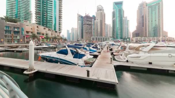 Dubai Marina met jachten in de haven en moderne torens vanaf bovenkant van wolkenkrabber overgang van dag naar nacht timelapse — Stockvideo