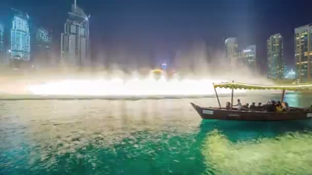 De boot drijft tegen de achtergrond van een dansende fontein in Dubai — Stockvideo