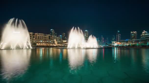 Timelapse fontein in de buurt van Burj Khalifa verlicht door de stad 's nachts dansen — Stockvideo