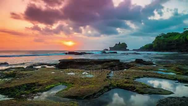 Timelapse van de zonsondergang op het strand gebroken. In de verte ziet men de tempel van Tanah Lot op het eiland Bali in Indonesië. — Stockvideo