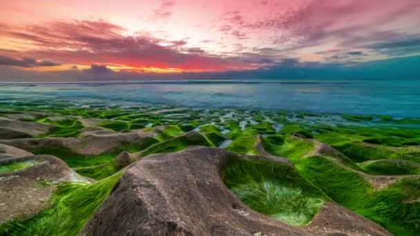Gyorsított a gyönyörű naplemente a tengerparton Balangan fagyasztott vulkáni tölcsérek borított algák Bali szigetén, Indonézia. — Stock videók