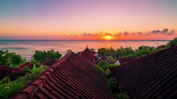 Timelapse se soluppgången bakgrunden av ocean och taket bungalows med tropiska träd i Amed på ön Bali i Indonesien. — Stockvideo