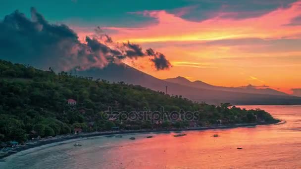 Scenario epico del tramonto nella baia di Jemeluk con vista sull'oceano e le nuvole sopra il vulcano Agung a Bali in Indonesia . — Video Stock