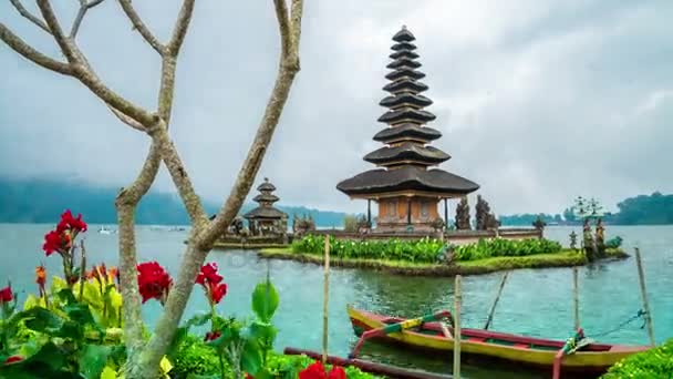 Piros virágok és a templom Pura Ulun Danu Batur-Bali, Indonézia. — Stock videók