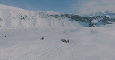 Bir helikopter ve kayakçılar ve snowboard kış dağlarda bir grup yakın hava iniş