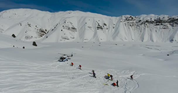 Narciarze i snowboardziści przejdź do helikoptera w górach zimą — Wideo stockowe