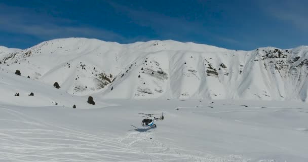 Vue aérienne Hélicoptère Blanc atterrissant dans les montagnes de neige — Video