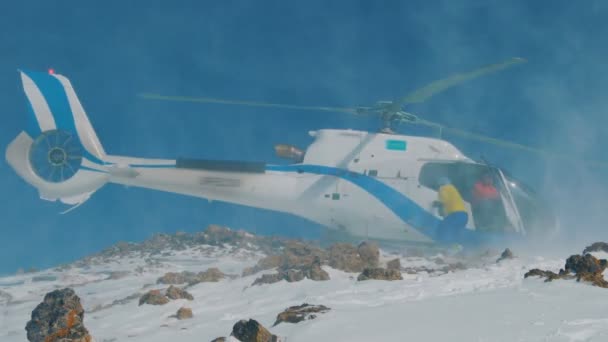 Der Hubschrauber landete im Winter in den Bergen und hob eine Schneewolke auf — Stockvideo