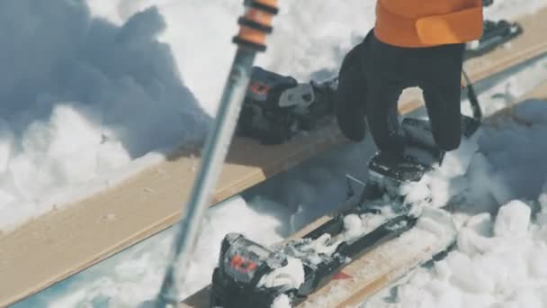 Skifahrer Hand entfernt Schnee von Skibefestigung Nahaufnahme — Stockvideo