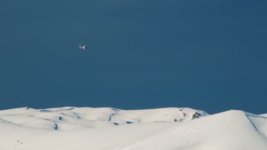 Heliskiing helikopter karla kaplı dağlar arka karşı uçar