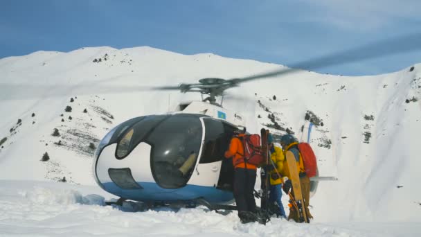 Лыжники садятся в вертолет, стоящий в снегу в зимних горах. Тянь-Шань, Шымкент, Казахстан - февраль 2018 года — стоковое видео