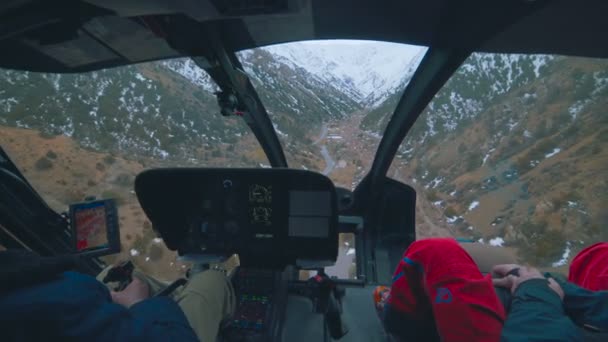 Visa från insidan av en helikopter som närmar sig över bergen — Stockvideo