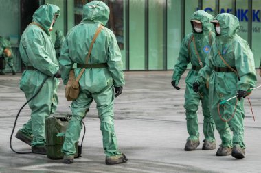 Biyolojik virüs koruyucu giysiler giyen tıp çalışanları Coronavirus COVID-19 caddesini dezenfekte ediyor. Antibakteriyel karantina önlemleri.