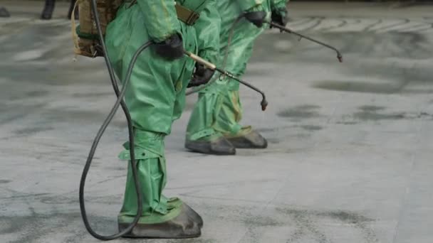 Los trabajadores con trajes de protección contra riesgos biovirales desinfectan el suelo y las superficies del coronavirus. Medidas sanitarias antibacterianas en cuarentena. UltraHD 4K — Vídeo de stock