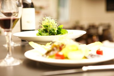 Salata ve kırmızı şarap masanın üstünde.