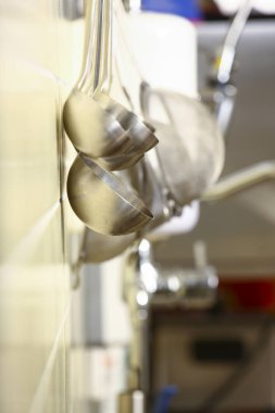 Beyaz duvarda asılı mutfak aletleri