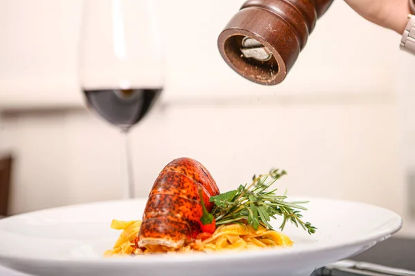 Pasta con camarones y molino de mano y pimienta y vino de vidrio en el fondo — Foto de Stock