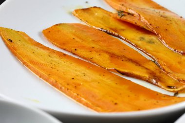 Masanın üstündeki yemek tabakları, karanlık bir masada misafirler için servis edilmeye hazır.