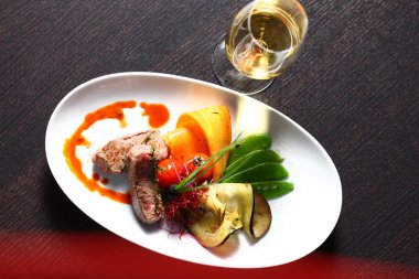 Lokantada lezzetli yemekler ve bir bardak şarap.