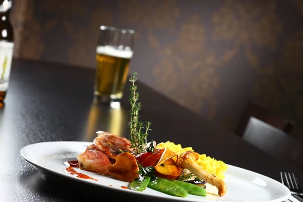 Plato con comida, arroz y champiñones y una cerveza en un comedor — Foto de Stock