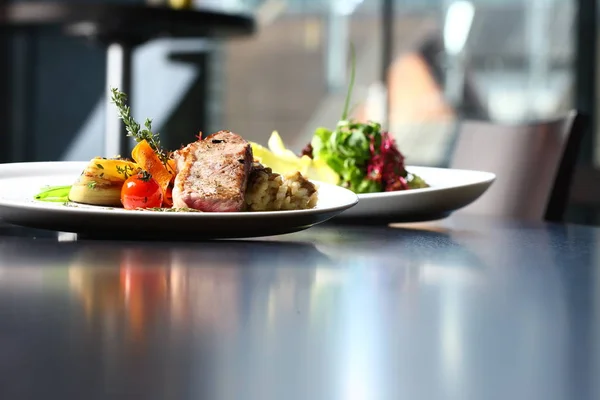 Sabrosa comida en la mesa en el restaurante, con carne y ensalada — Foto de Stock