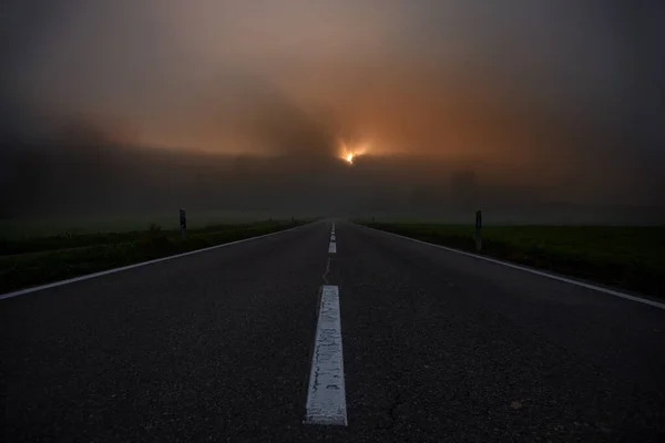 Camino hacia el horizonte durante el amanecer con niebla —  Fotos de Stock
