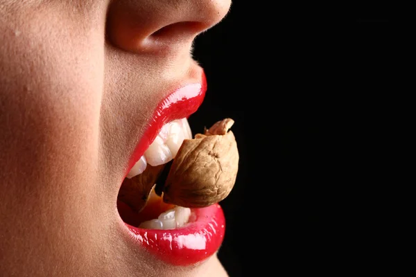 Vrouw rode lippen eten lekker eten. vrouw kraken een moer — Stockfoto