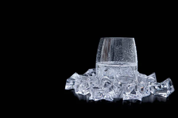 Glass of water with ice and bubbles on black background — 스톡 사진