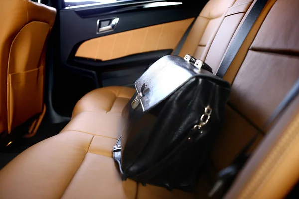 business leather briefcase on backseat of luxury car