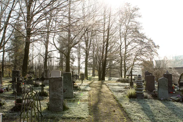 Güneş ışınları gün batımında mezarlıkta parlıyor — Stok fotoğraf