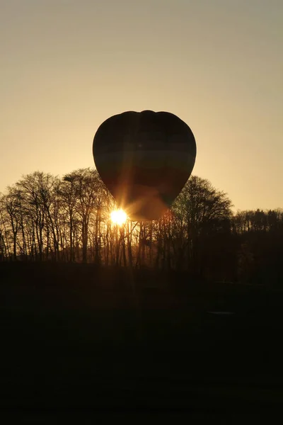Hot air balloon landing during sunset